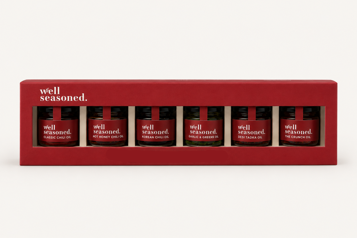 Box of 'well seasoned' mini oil bottles on a white background